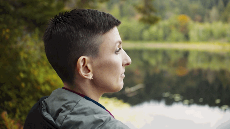 Photograph of Jen, a woman with HER2+ breast cancer, looking out at a lake